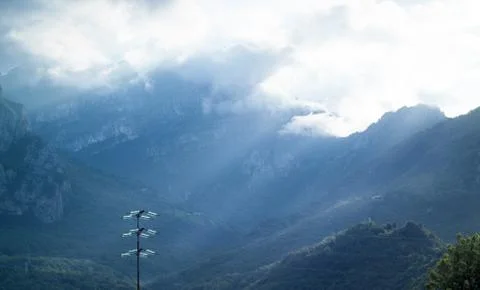 Dramatic light falling from the sky in Italy, with a shiny utility pole in th Stock Photos