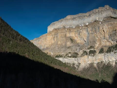 Dramatic light on a rocky mountain face - Dramatic sunlight and deep shadow.. Stock Photos