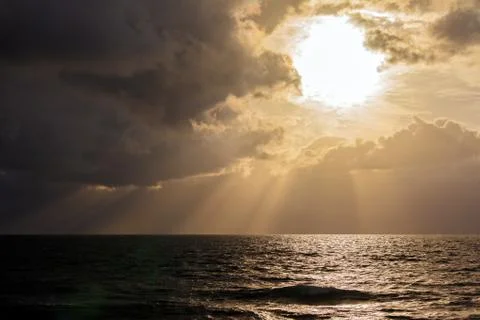Dramatic light with sun rays and heavy clouds Stock Photos