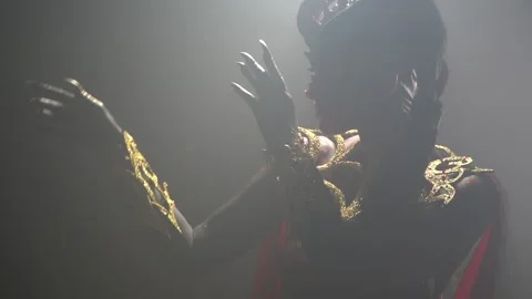 Dramatic lighting, female demon wearing golden armor, moving her hands Stock Footage 138139869