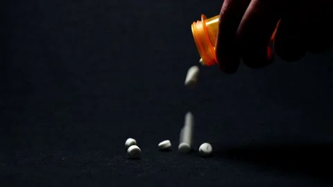 Dramatic Lighting Over Pouring Out White Pills From Bottle Stock Footage 249356576