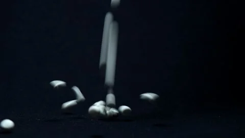 Dramatic Lighting over White Pills Being Spilled onto Black Surface Stock Footage 249356043