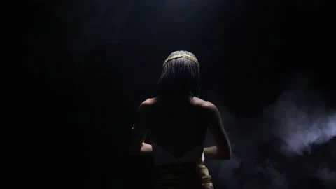 Dramatic lighting with smoke, Cleopatra is dancing, view from the back Stock Footage 138140130