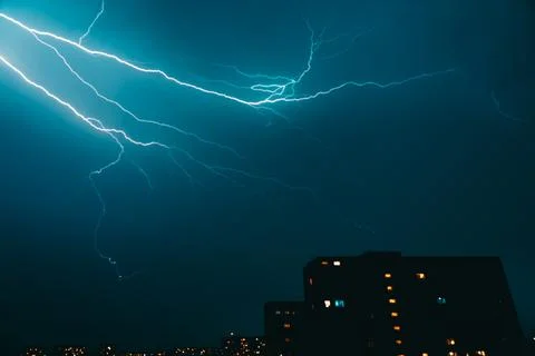 Dramatic lightning across night sky over city skyline Stock Photos