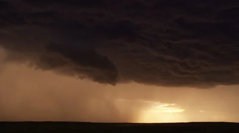 Dramatic lightning flash at edge of storm cloud advancing over the prairie at Stock Footage 59525771