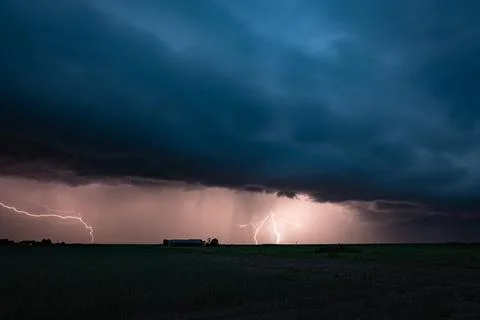 Dramatic lightning storm over rural farm field with dark clouds Foto stock