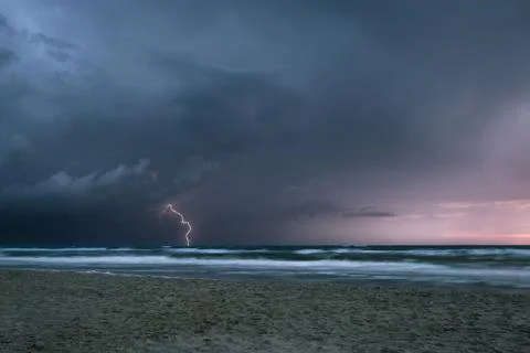 Dramatic lightning storm over the sea just after sunset Stock Photos