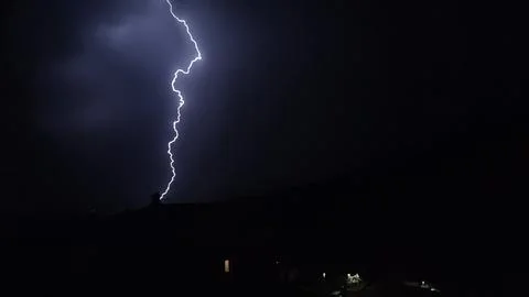 Dramatic lightning strike cutting through the darkness of the night sky Stock Photos