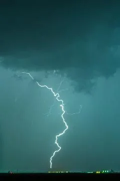 Dramatic lightning strike over flat landscape, night storm with turbulent clouds Stock Photos
