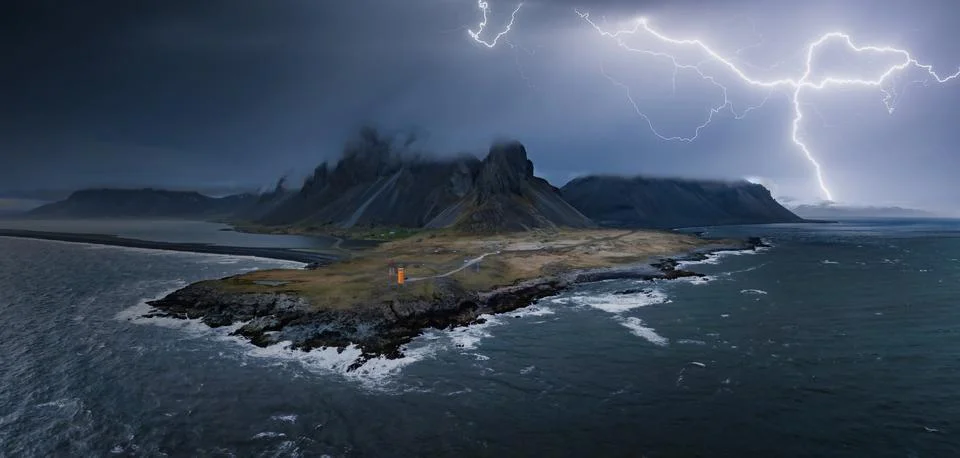 Dramatic Lightning Strike Over Rugged Icelandic Coastline at Night Foto stock