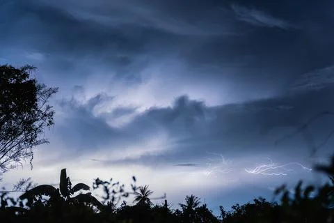 Dramatic lightning thunderstorm striking in the night sky over rural landscap Stock Photos