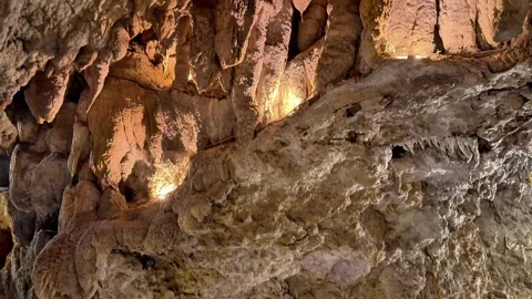 Dramatic Limestone Cave Formations Illuminated by Warm Lighting Stock Footage 345372544