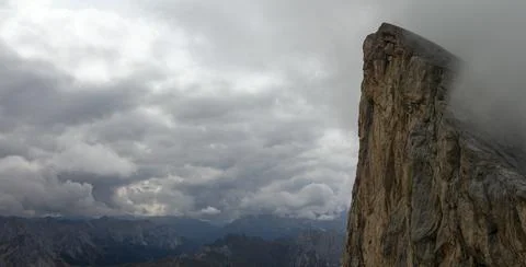 Dramatic limestone cliff emerging from clouds in Dolomites mountains Italy 스톡 사진