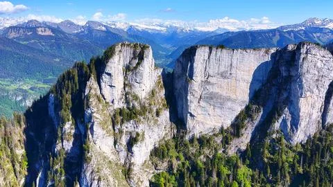 Dramatic Limestone Cliffs Above Alpine Valley and Snowy Peaks Photos