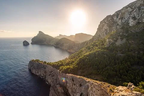 Dramatic limestone cliffs and pine forests of Cap de Formentor at golden suns Stock Photos