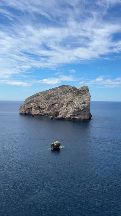 Dramatic limestone islet of Isola di Foradada with a natural arch tunnel  Stock Footage 333795289