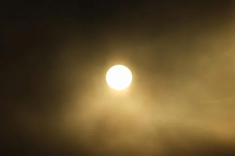 Dramatic lit by sun rising fog over water. Stock Photos