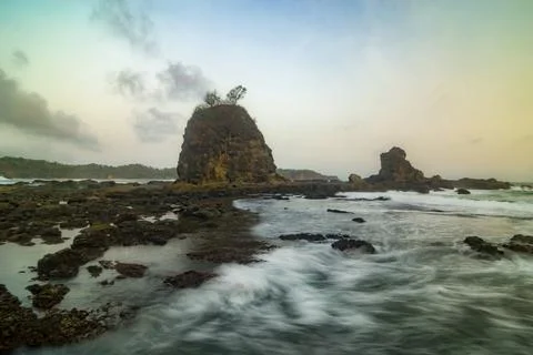 Dramatic long exposure of sea waves crashing over rocky formations. Stock Photos