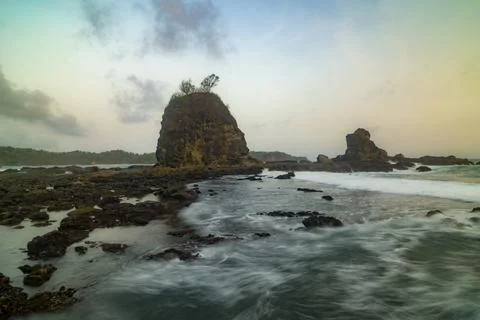 Dramatic long exposure shot of sea waves crashing over rocky formations. Stock Photos