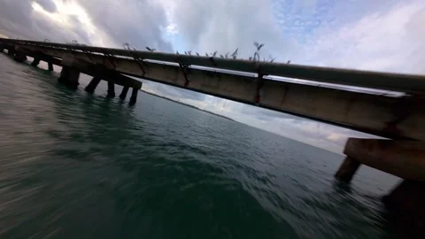 Dramatic low-angle shot captures pier's silhouette against dark, cloudy sky Stock Footage 344543032