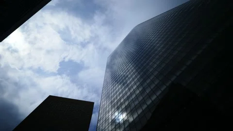 Dramatic low angle shot of modern office tower, clouds rush on sky, sun shine 스톡 동영상 130285930
