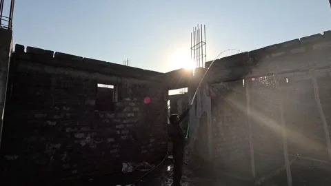 Dramatic low angle tracking view capturing a male manual builder holding a green Stock Footage 337869587