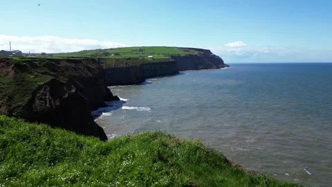 Dramatic low flying reveal over cliffside drop off to see ocean water Video stock 243003684