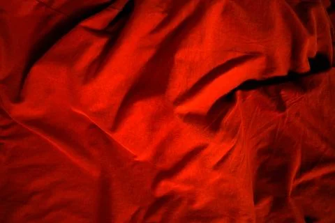 Dramatic low-key lighting on crumpled dark red fabric, highlighting rich te.. Stock Photos