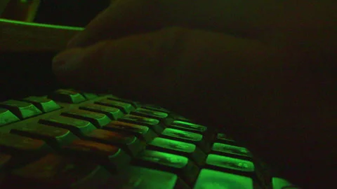 Dramatic macro shot of fingers typing on computer keyboard at night Stock Footage 335635666