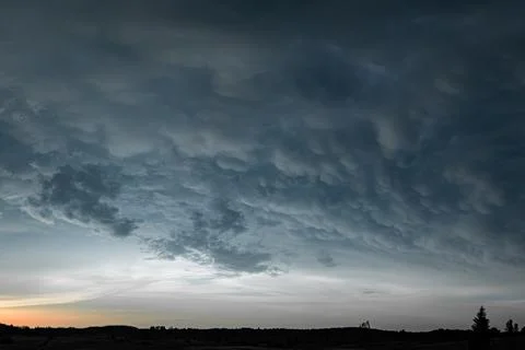 Dramatic Mammatus Cloud Formation Looming Over Forest at Sunset Stock-Fotos