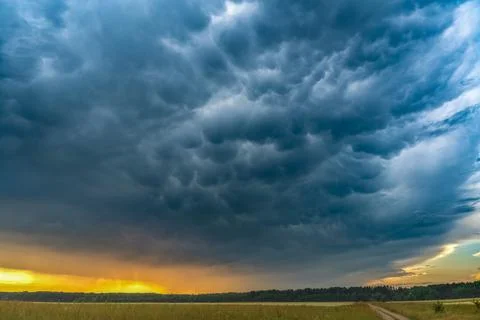 Dramatic Mammatus Storm Clouds over Countryside at Sunset Stock Photos
