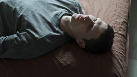 Dramatic man crying in despair. Portrait of emotional man lies on the bed and Stock Footage 308939460