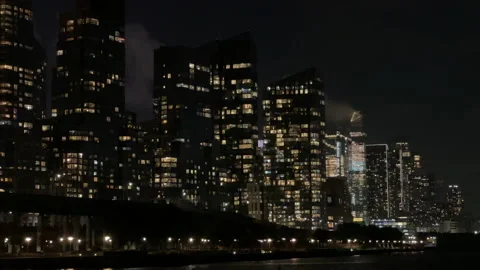 Dramatic Manhattan skyline rising over Hudson River Waterfront Greenway at night Stock Footage 230458402