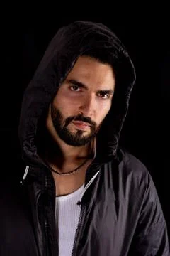Dramatic medium shot of handsome bearded man wearing dark hood Stock Photos