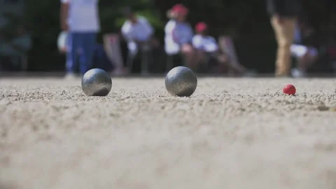 Dramatic moment of impact in a petanque game as metal balls collide, sending Stock Footage 310570667