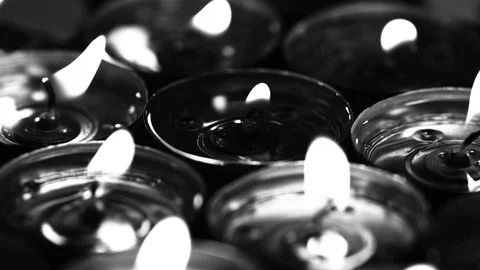 Dramatic monochrome of candles burning in the dark in UHD Stockbeeldmateriaal 95708352
