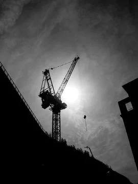 Dramatic monochrome picture of a construction tower crane silhouette Stock Photos