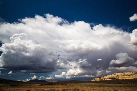 Dramatic monsoon storm cloud builds over a desolate desert area Stock Photos