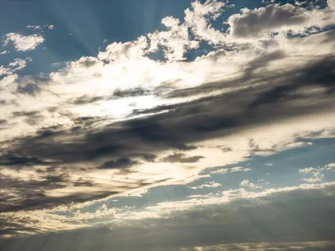 Dramatic morning cloudscape with the sun glowing behind dark layered clouds and Foto stock