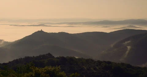 Dramatic mountain and hill tops with fog moving in the valley 動画素材 243105793