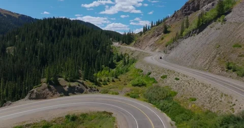 Dramatic Mountain Hairpin Turn Surrounded by Alpine Forest 스톡 동영상 329455729