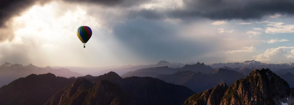 Dramatic Mountain Landscape covered in clouds and Hot Air Balloon Flying. Stock Illustration