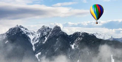 Dramatic Mountain Landscape covered in clouds and Hot Air Balloon Flying. Stock Illustration