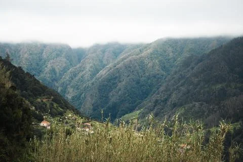 Dramatic mountain landscape with a settlement nestled in a valley, conveying  Stock Photos