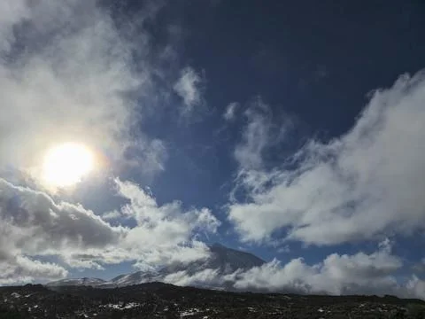 Dramatic mountain landscape with sun and clouds Stock Photos