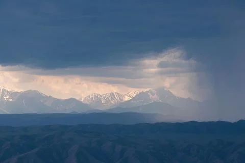 Dramatic mountain landscape under storm clouds with rain stripe and copy spac Stock Photos
