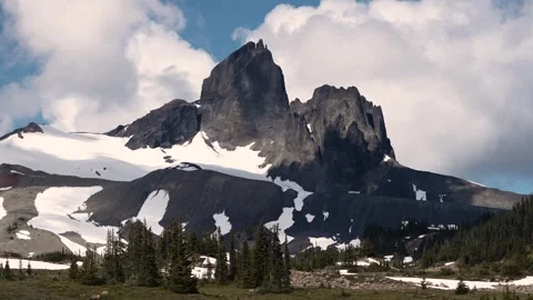 Dramatic mountain peak clouds moving fast sunny day snowy snow glacier hikin Stockbeeldmateriaal 277669181