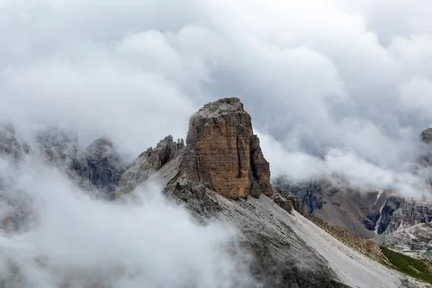 Dramatic mountain peak rising up in the clouds in the dolomites Stock Photos