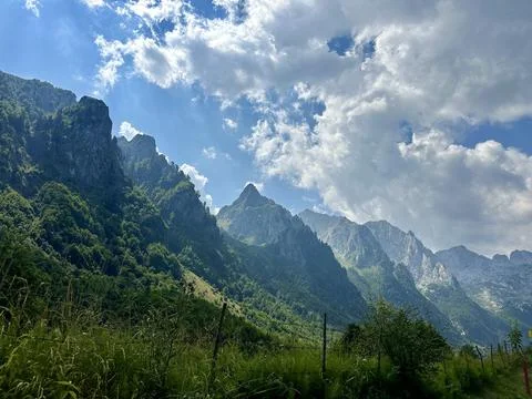 Dramatic mountain peaks with bright blue sky and clouds in the background Stock Photos