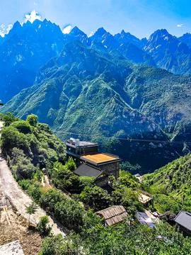 Dramatic Mountain Peaks with Remote Hillside Building Stock Photos